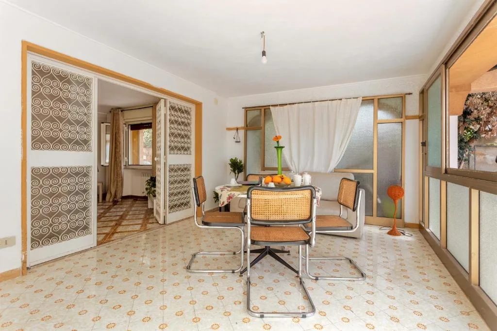 Veranda luminosa di Casa Tolomea a Mondello, tavolo da pranzo
